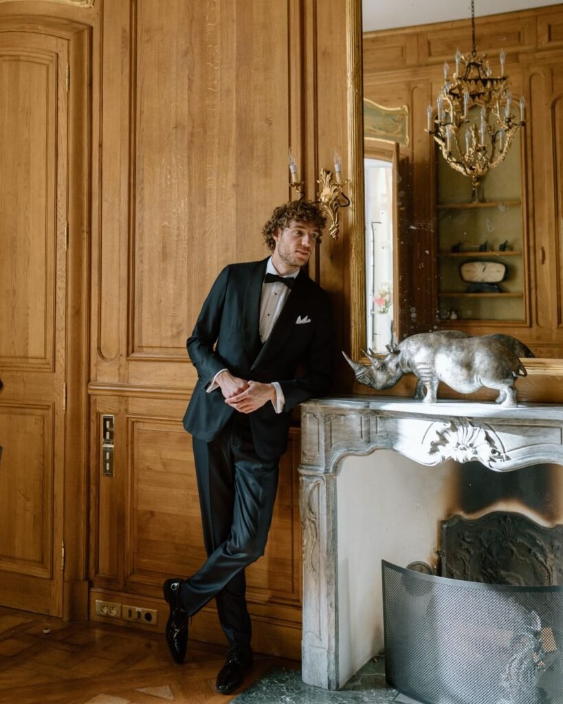 Handsome groom posing for a portrait in a classic suit, captured by Arlene Leilani.