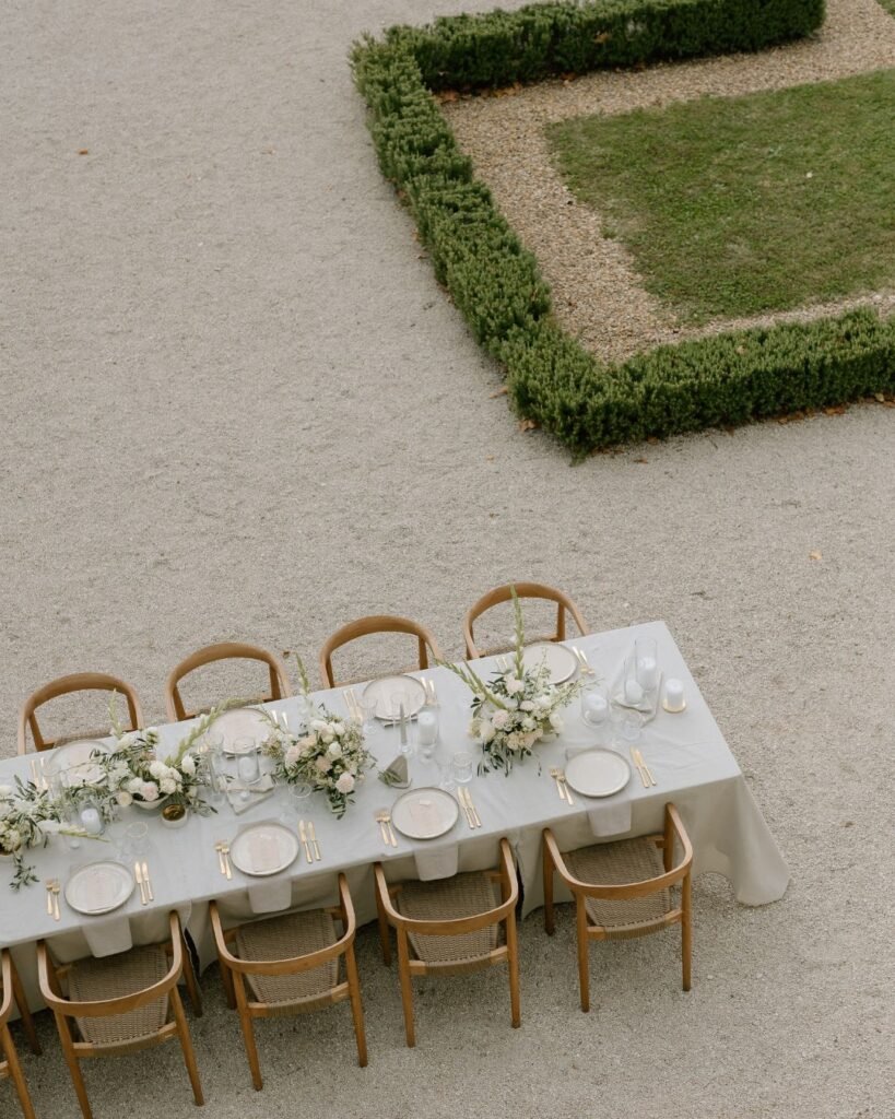 Stunning reception tablescape with candles, greenery, and gold accents, photographed by Arlene Leilani.