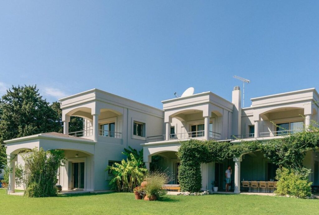 Entrance to Bello Blu in Greece, surrounded by beautifully landscaped gardens and Mediterranean greenery.