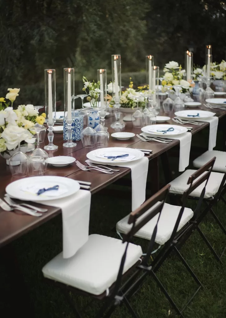 Close-up of reception table with crystal glassware, white florals, and soft candlelight at Borgo Tre Rose.