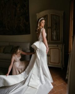 The bride in a sunlit suite at Rosewood Castiglion del Bosco, putting on earrings before the ceremony.