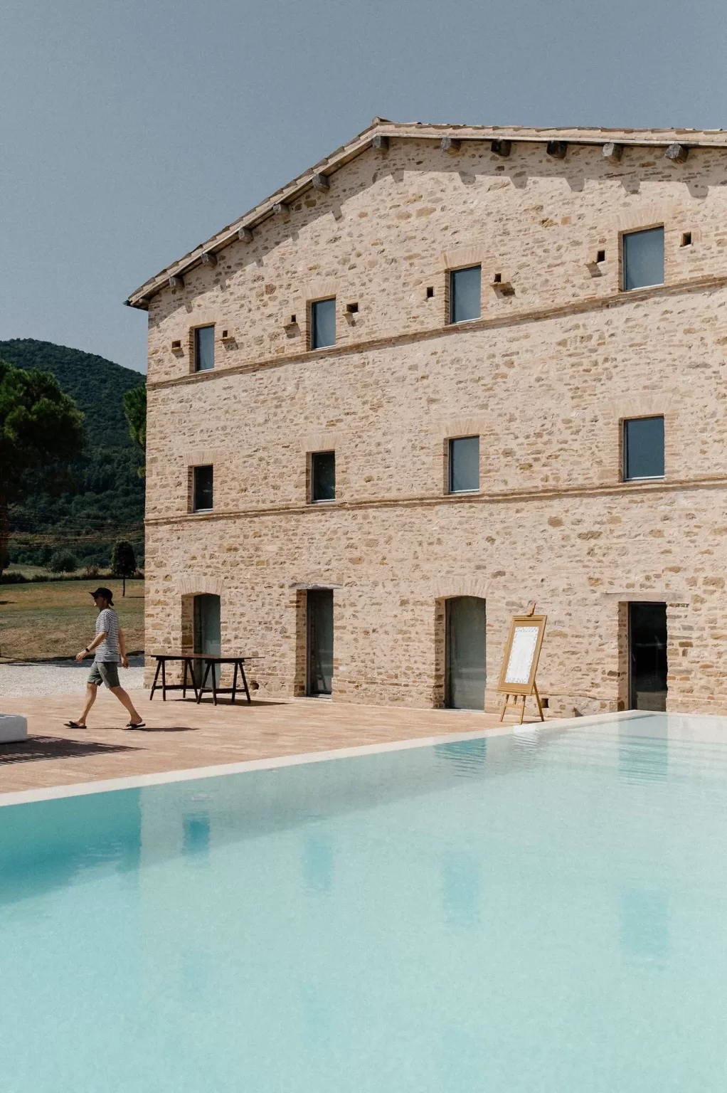 Sunlit stone building by the pool at Casa Olivi wedding venue