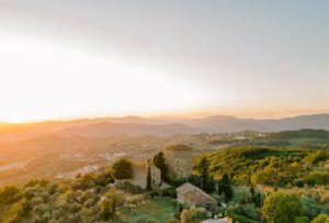 Stunning aerial view of Castello di Ristonchi, showcasing the historic Tuscan castle surrounded by rolling hills and lush countryside.