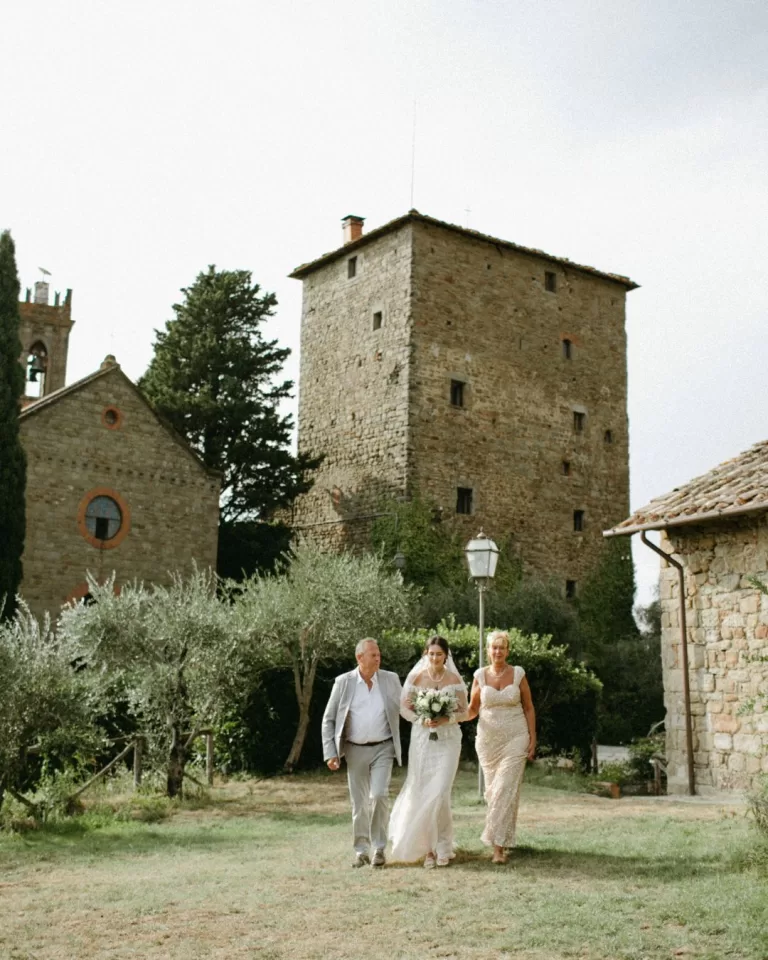 Bride walking down the aisle at Castello di Ristonchi, surrounded by romantic floral arrangements and historic charm.