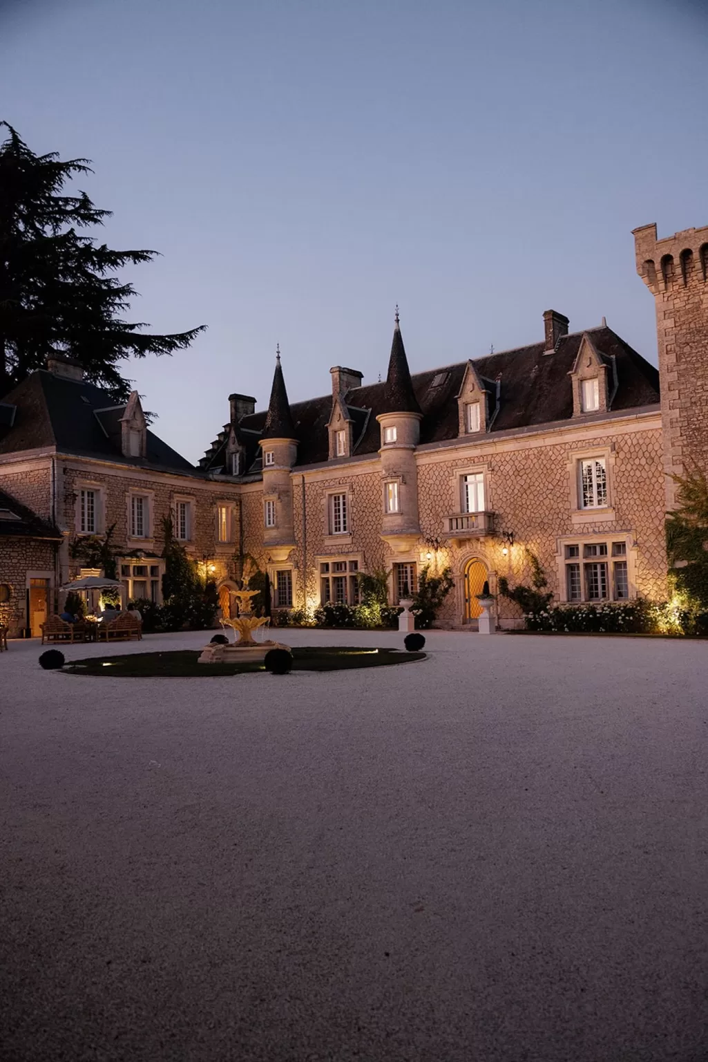 Château de la Couronne courtyard glowing with evening lights.