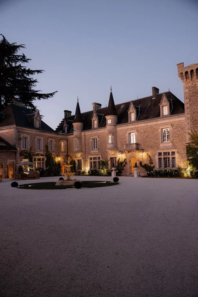 Château de la Couronne courtyard glowing with evening lights.
