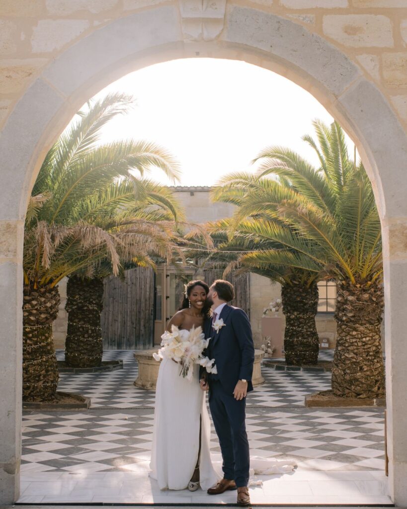 A couple sharing an intimate moment in the charming courtyard of Chateau de Garde in France, photographed by Alex Tome.