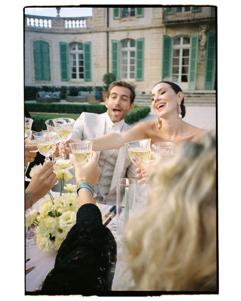 The newlyweds embrace in the picturesque courtyard of Chateau de Tourreau, surrounded by historic architecture.