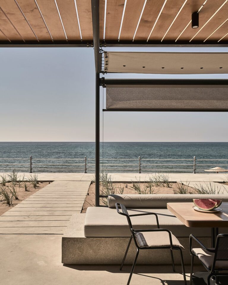 Outdoor lounge area at Dexamenes Seaside Hotel in Greece, designed with minimalist, industrial décor overlooking the beach.
