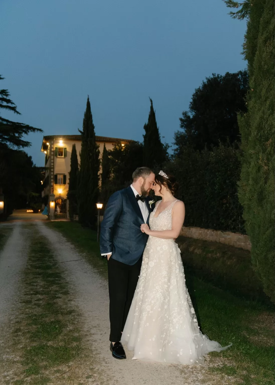Bride and groom sharing an intimate moment outside Villa Ivana Cortona as the villa lights glow at dusk.