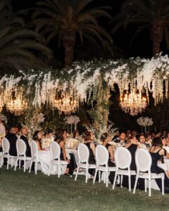 A beautifully decorated wedding reception table under the palm trees at Finca La Concepción, captured by Nora Photography.