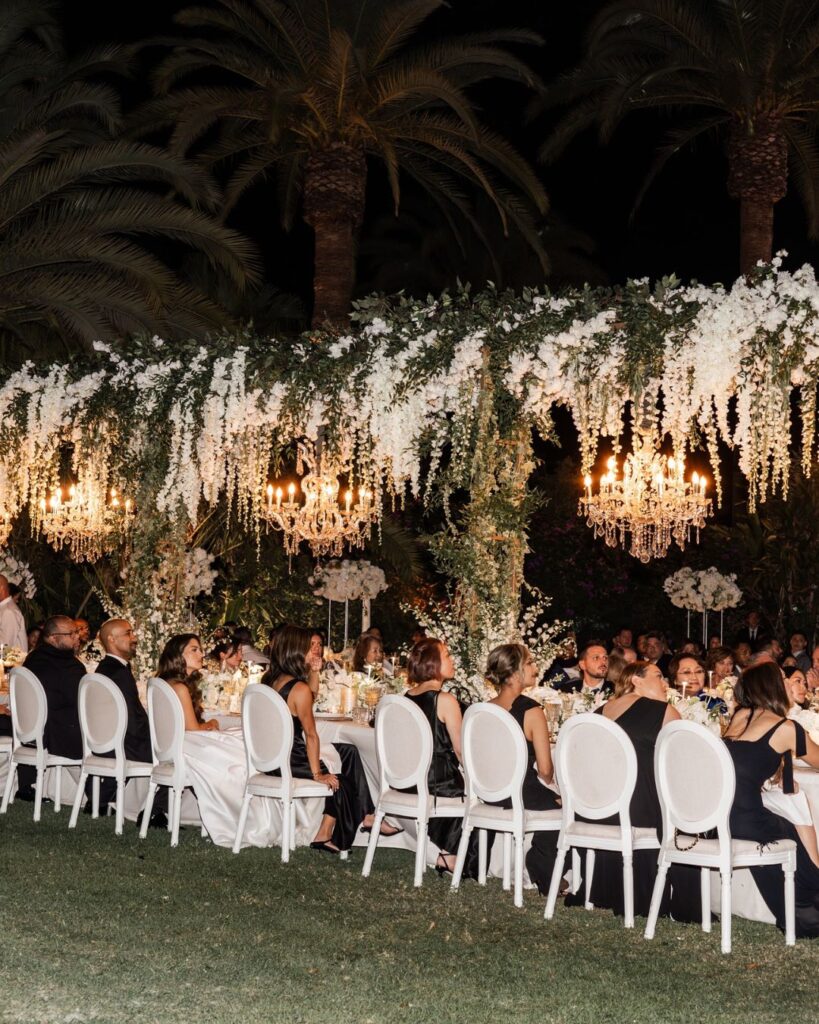 A beautifully decorated wedding reception table under the palm trees at Finca La Concepción, captured by Nora Photography.