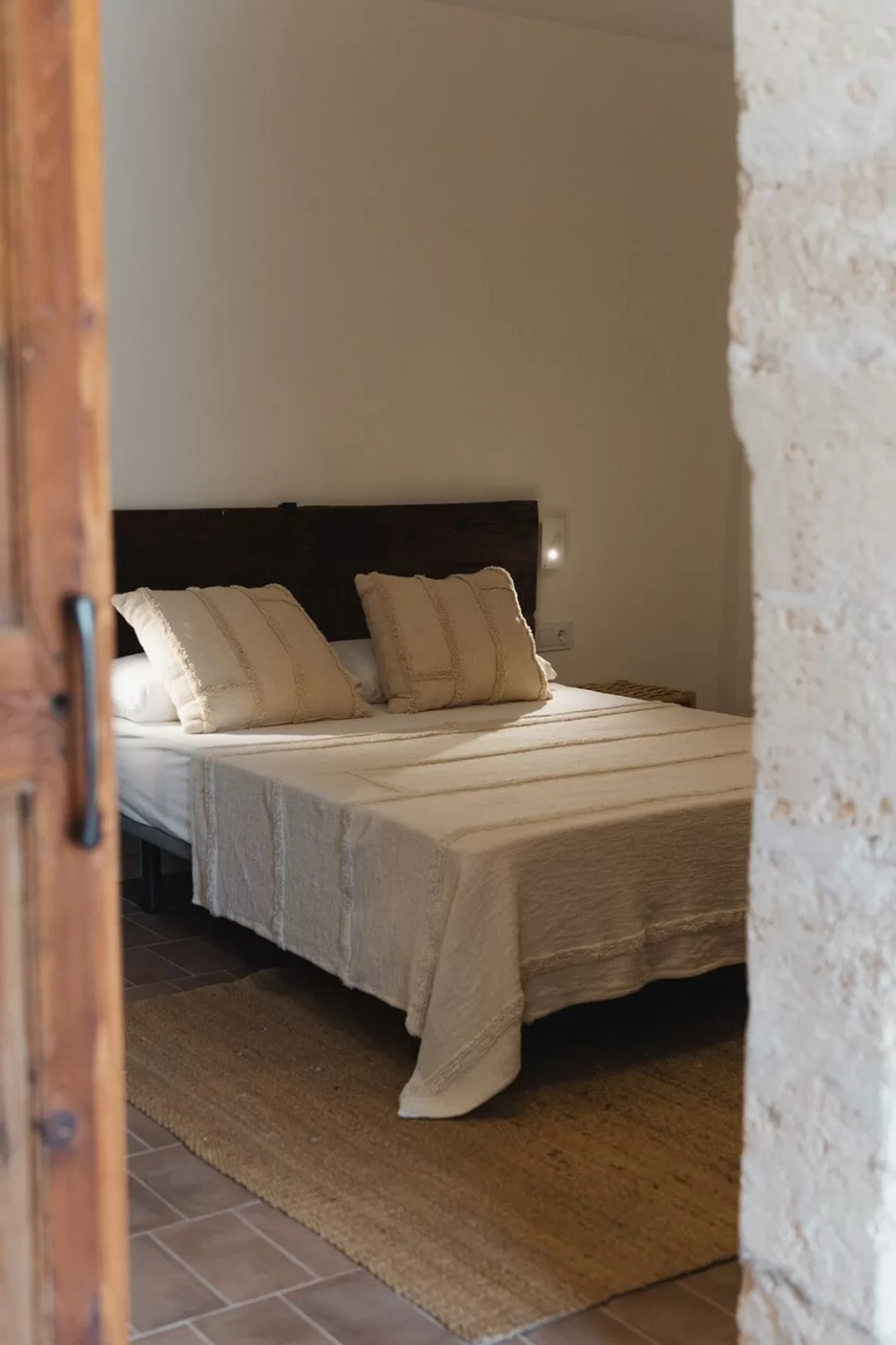 Cozy rustic double bedroom with natural linen bedding at Finca Son Sampol.