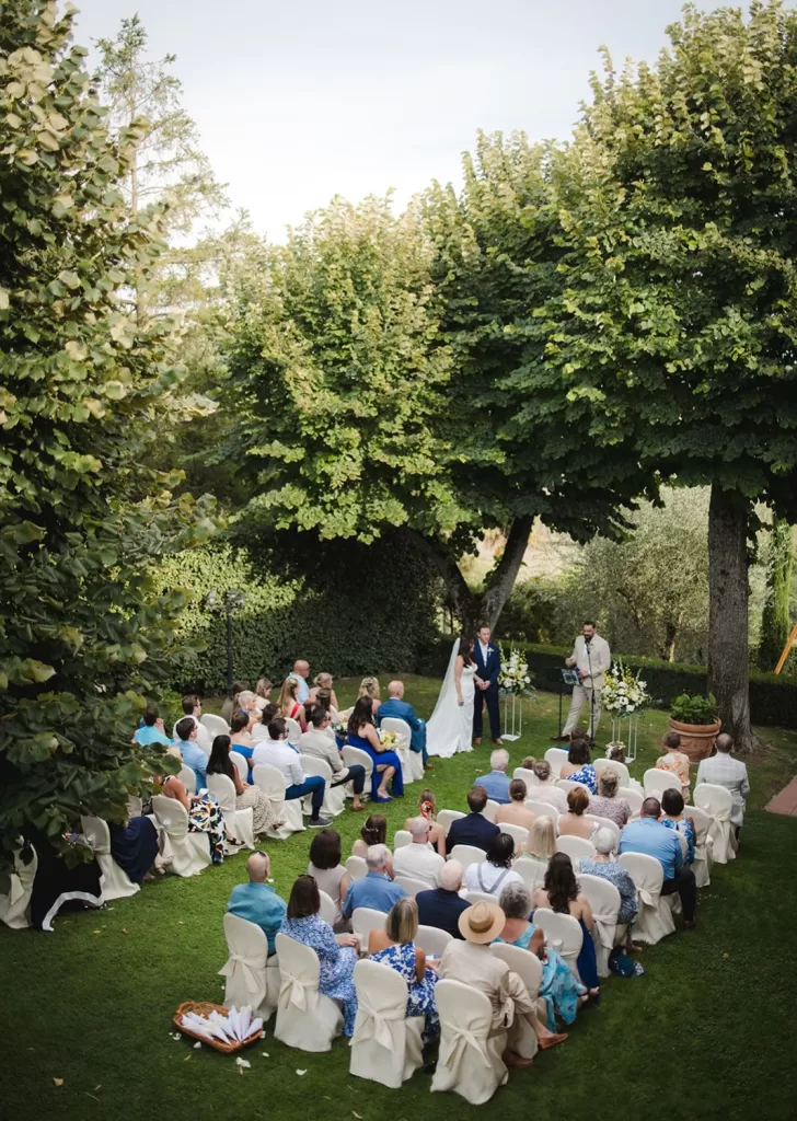 Outdoor wedding ceremony under trees with guests at Borgo Tre Rose