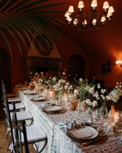 A refined indoor reception setup at Rosewood Castiglion del Bosco, featuring elegant tableware and floral centerpieces.