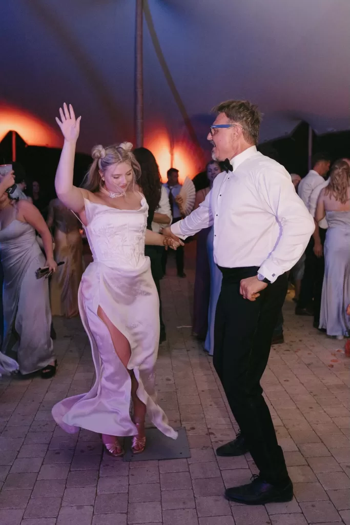 Guests dancing under a stretch tent at Masia Cabellut, bride in silk gown celebrating with loved ones