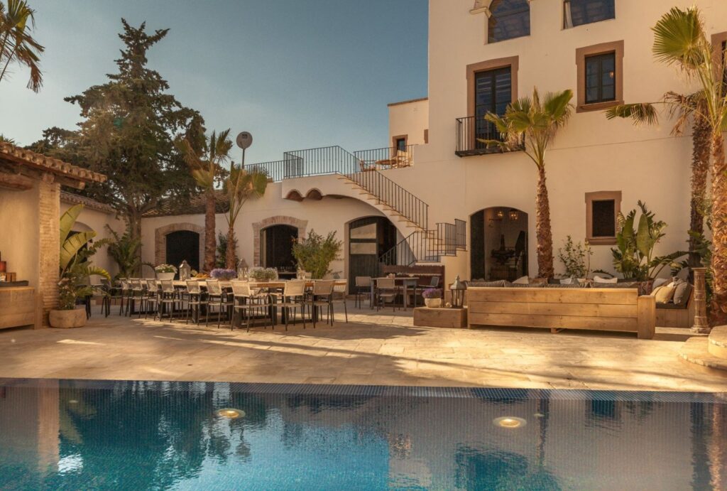 The rustic stone facade of Masia Victoria, showcasing its historic charm and Mediterranean architecture.