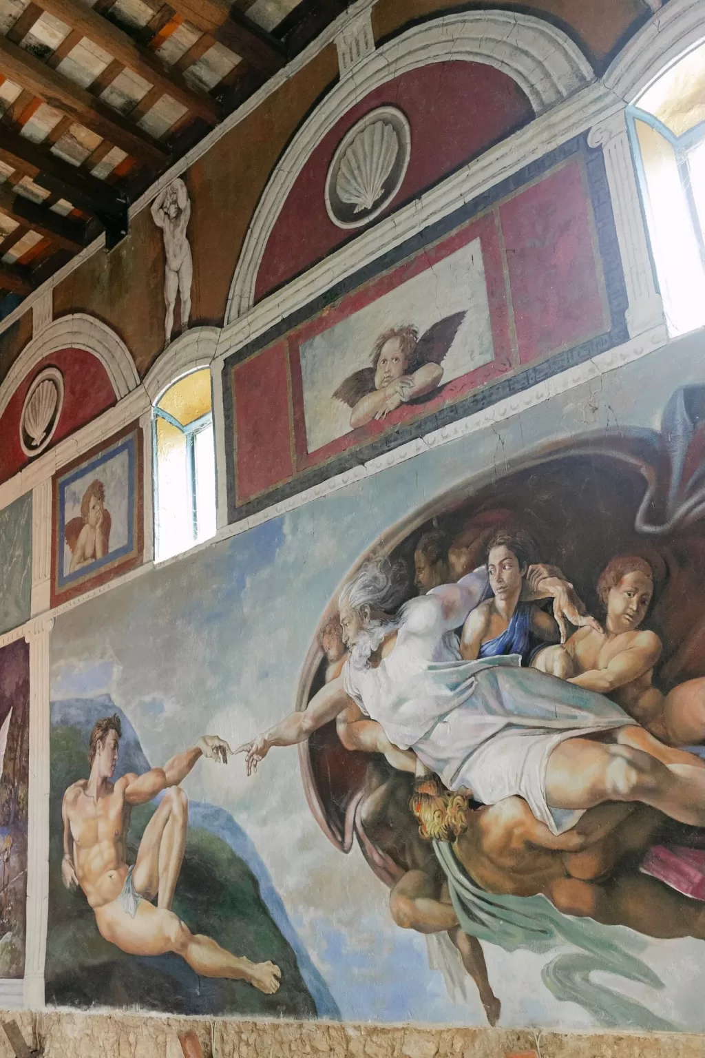 Detailed wall mural inside Masia Victoria featuring a recreation of Michelangelo’s Creation of Adam.