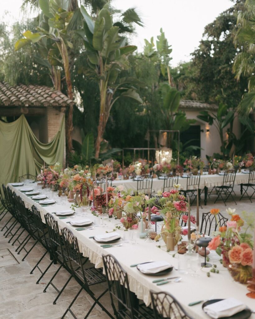 A beautifully arranged rustic wedding table setup at Masia Victoria, featuring elegant floral centerpieces and candlelit ambiance.