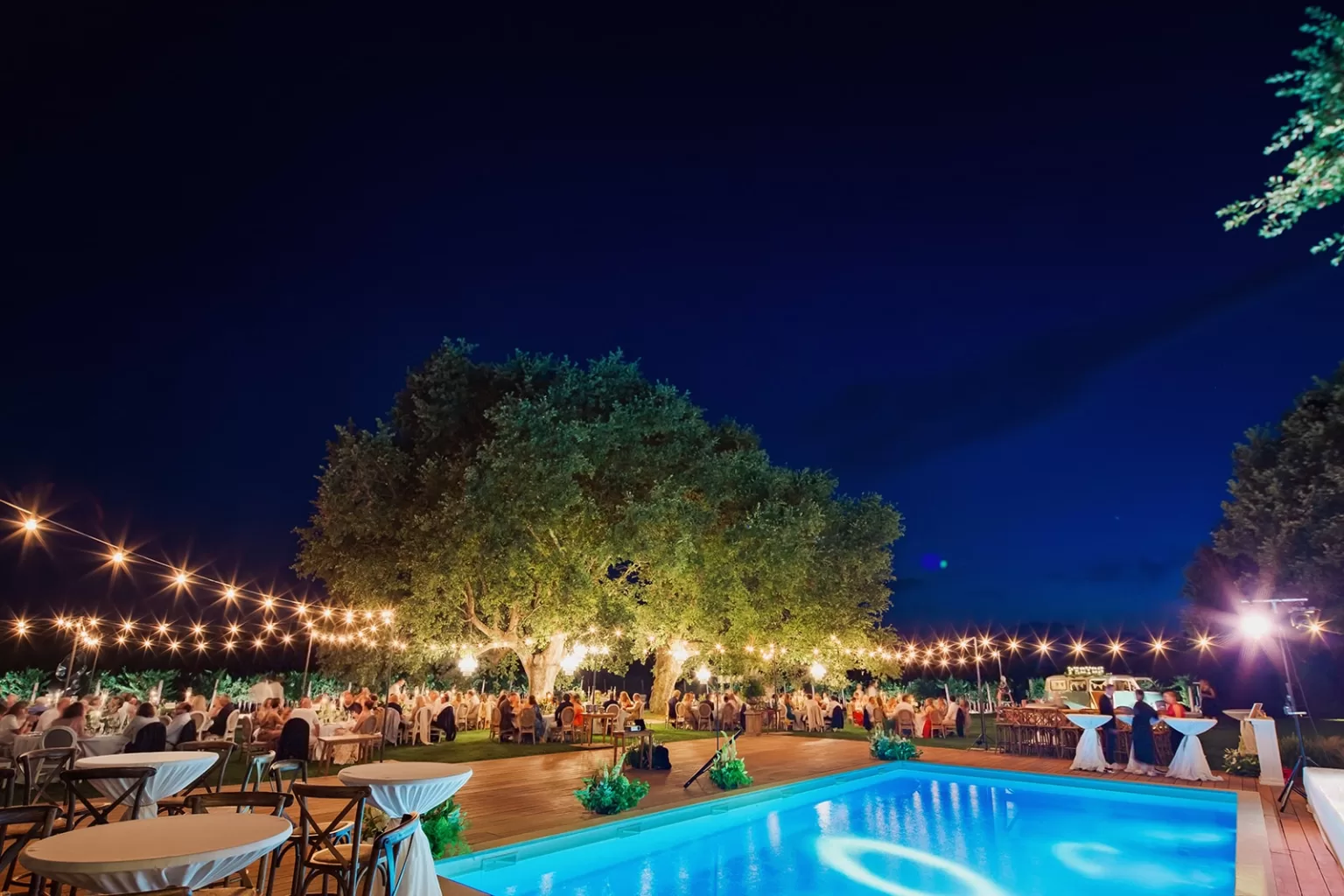 Outdoor wedding setup under chandeliers surrounded by vineyards at Meneghetti Wine Hotel in Croatia.