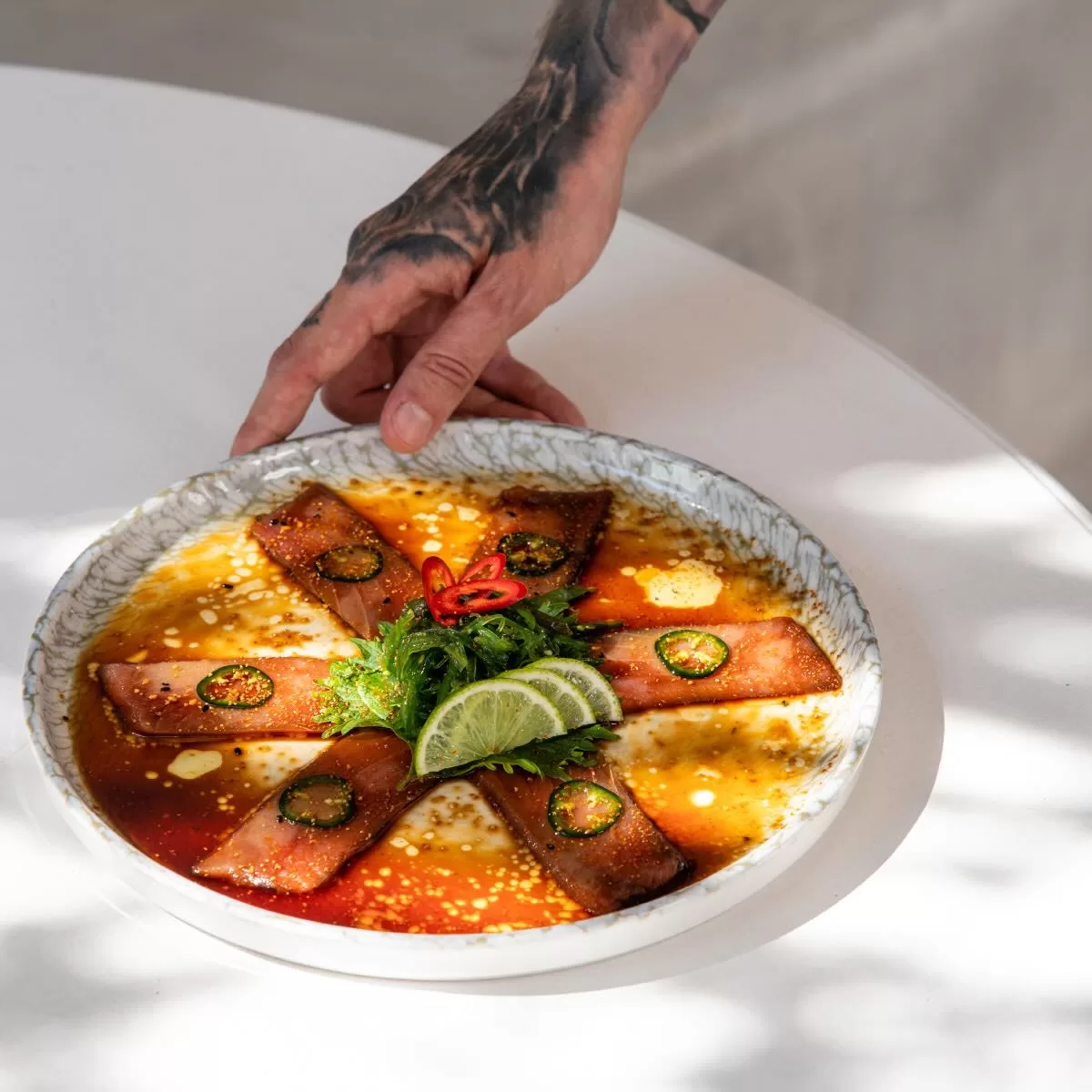 Gourmet seafood plate with lime and chili served in the sun at Mykonos Blu restaurant.