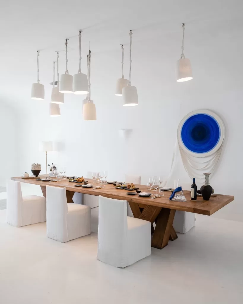 Minimalist private dining space at Mykonos Blu with a wooden table set for a luxurious gathering.