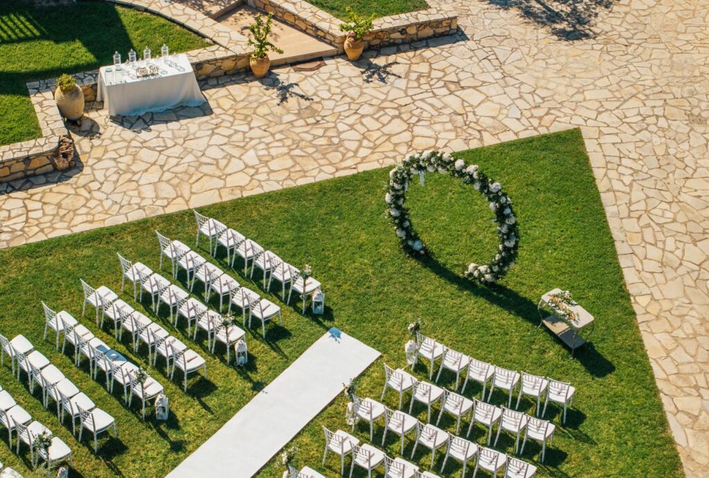 Romantic wedding ceremony setup at Palazzo di P with floral arch and scenic views