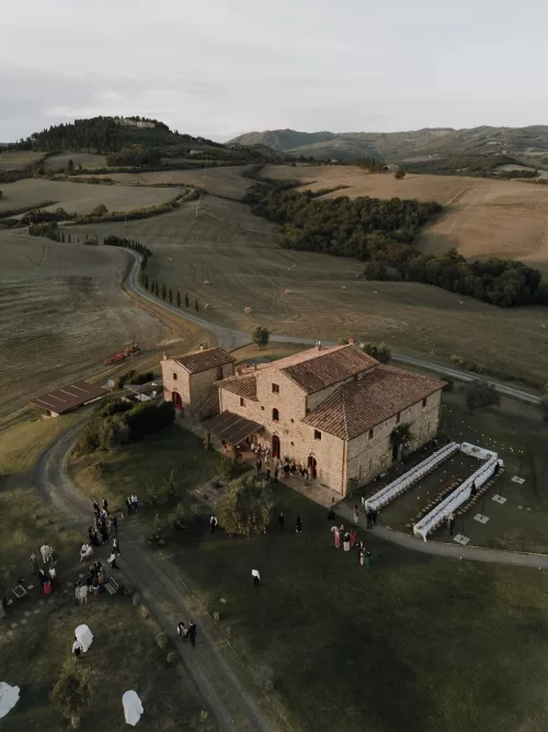 Drone photo of Podere Calvaiola surrounded by golden Tuscan countryside during an autumn wedding celebration.
