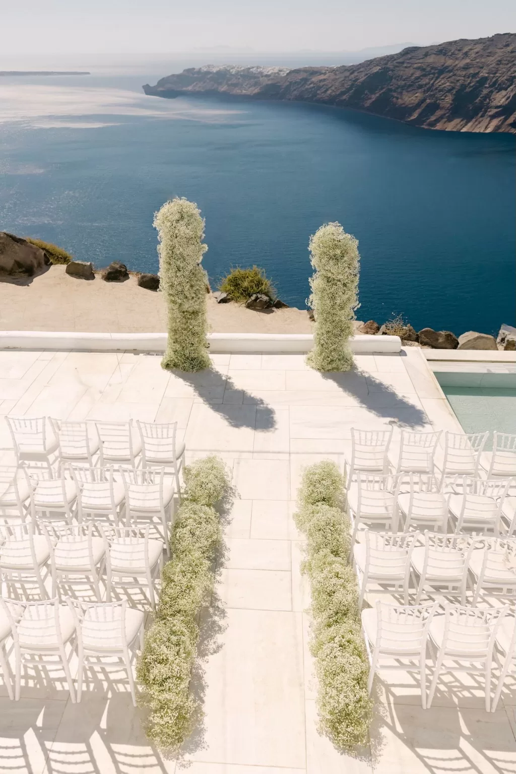 Minimal outdoor wedding ceremony setup at Rocabella Santorini with endless sea backdrop