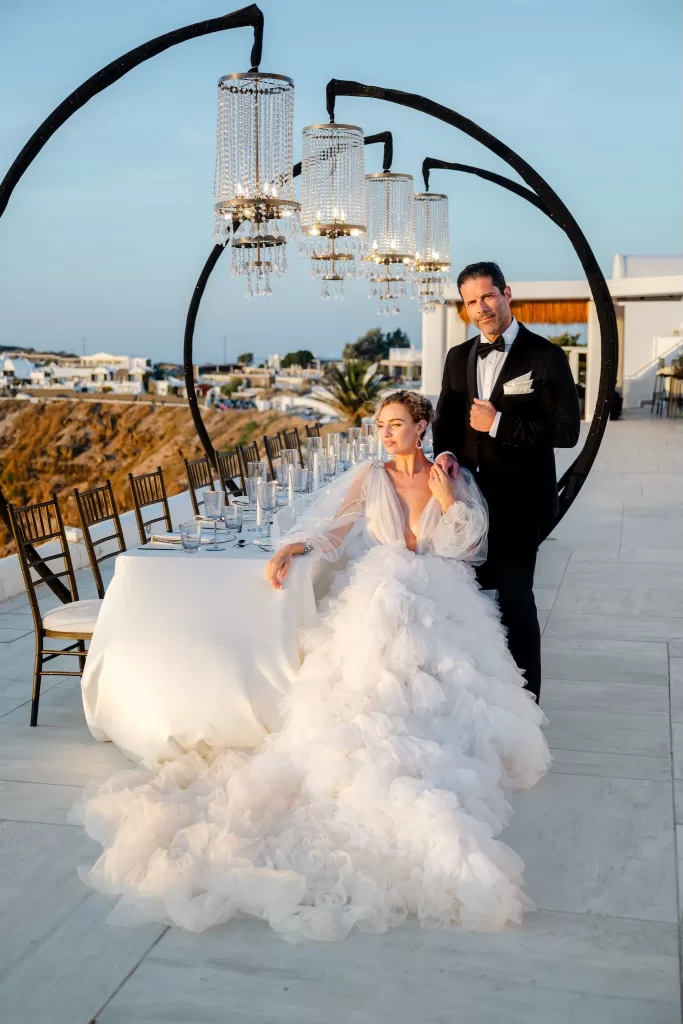 Bride and groom dining al fresco under lights at Rocabella Santorini