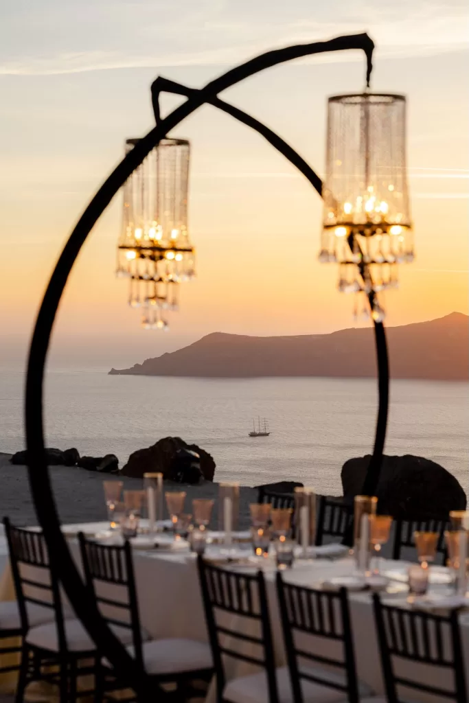 Sunset hues casting a warm glow over wedding dinner at Rocabella Santorini