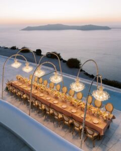 Bride and groom walking down the scenic path at Rocabella Santorini, surrounded by breathtaking views of the sea and cliffs.