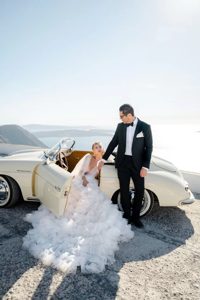 Bride and groom arrive in vintage convertible at Rocabella Santorini