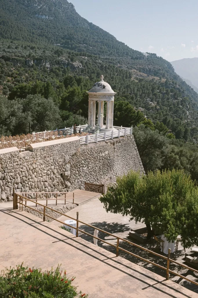 View of Son Marroig’s marble pavilion perched on the cliffside surrounded by lush mountains and sea.