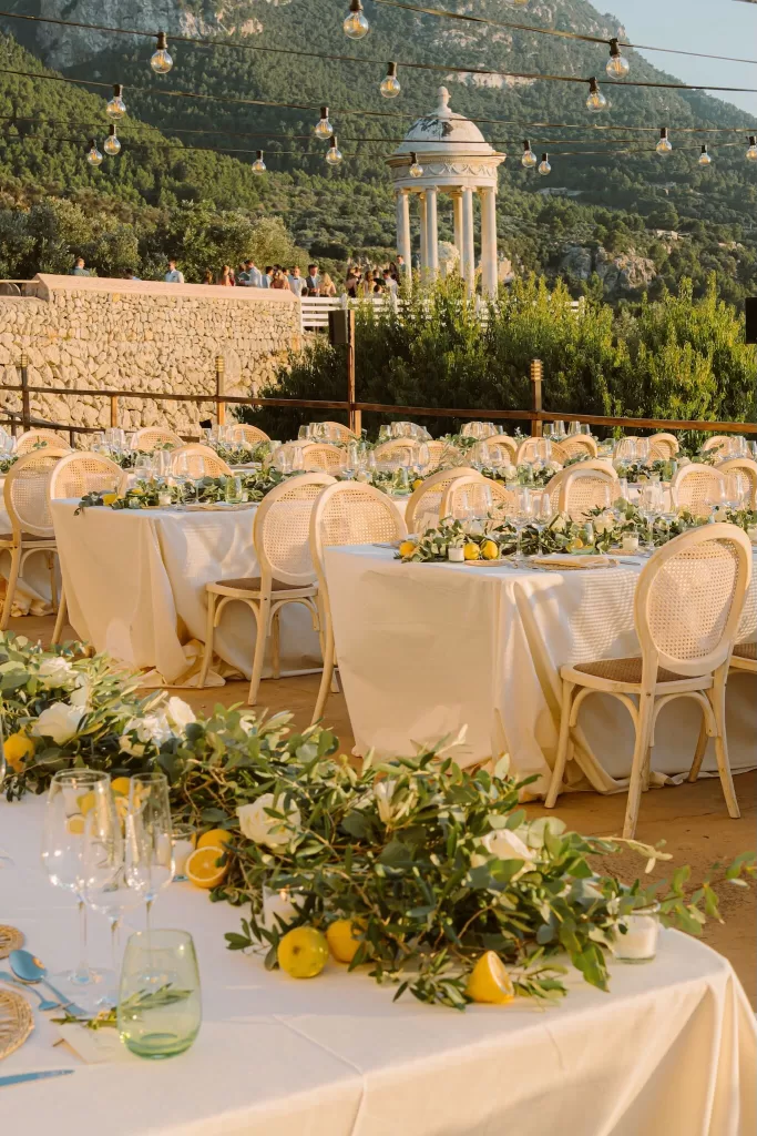 Elegant wedding reception tables with lemon and greenery décor on the terrace at Son Marroig.