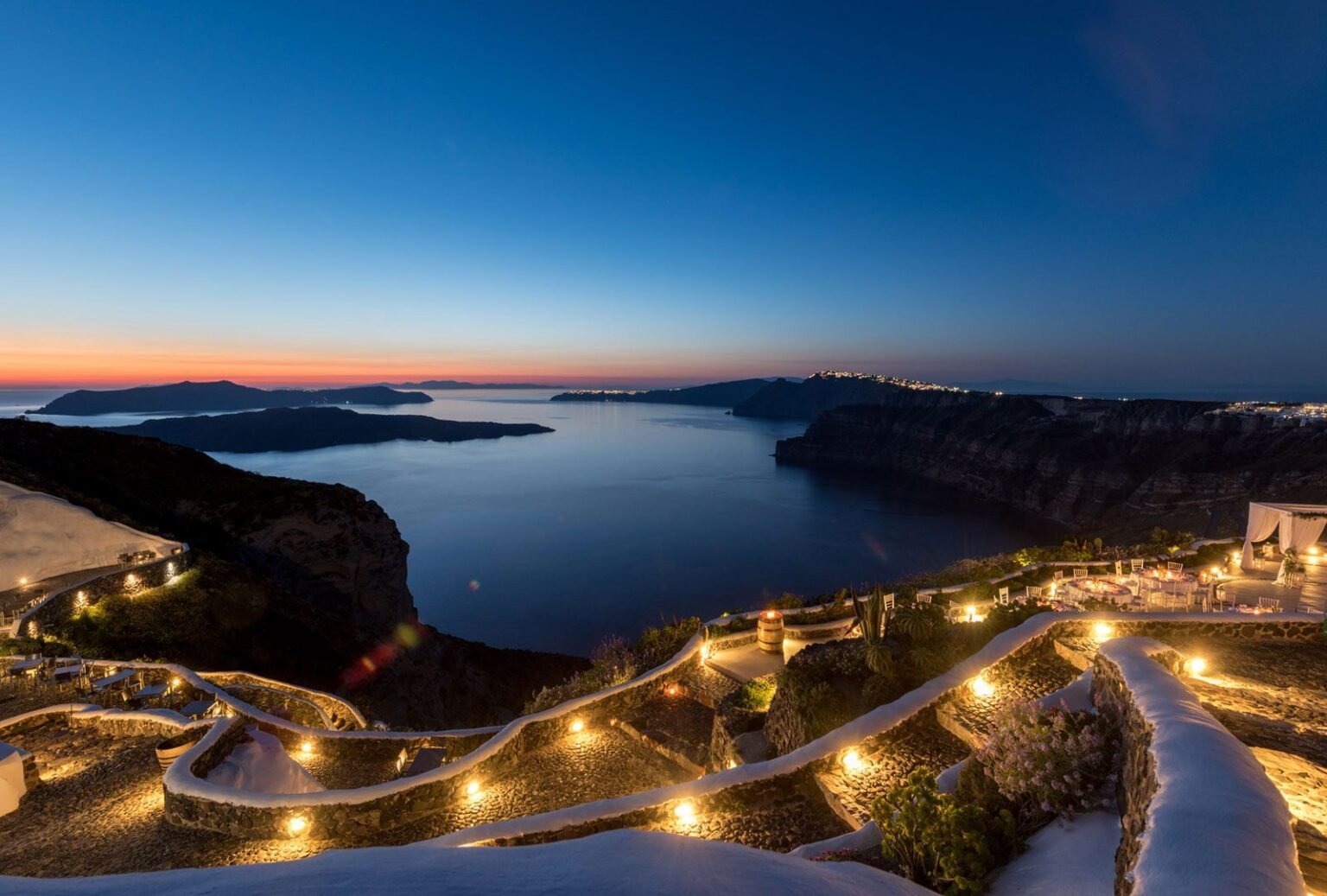 Picturesque courtyard at Venetsanos Winery, with charming stone walls and lush greenery.