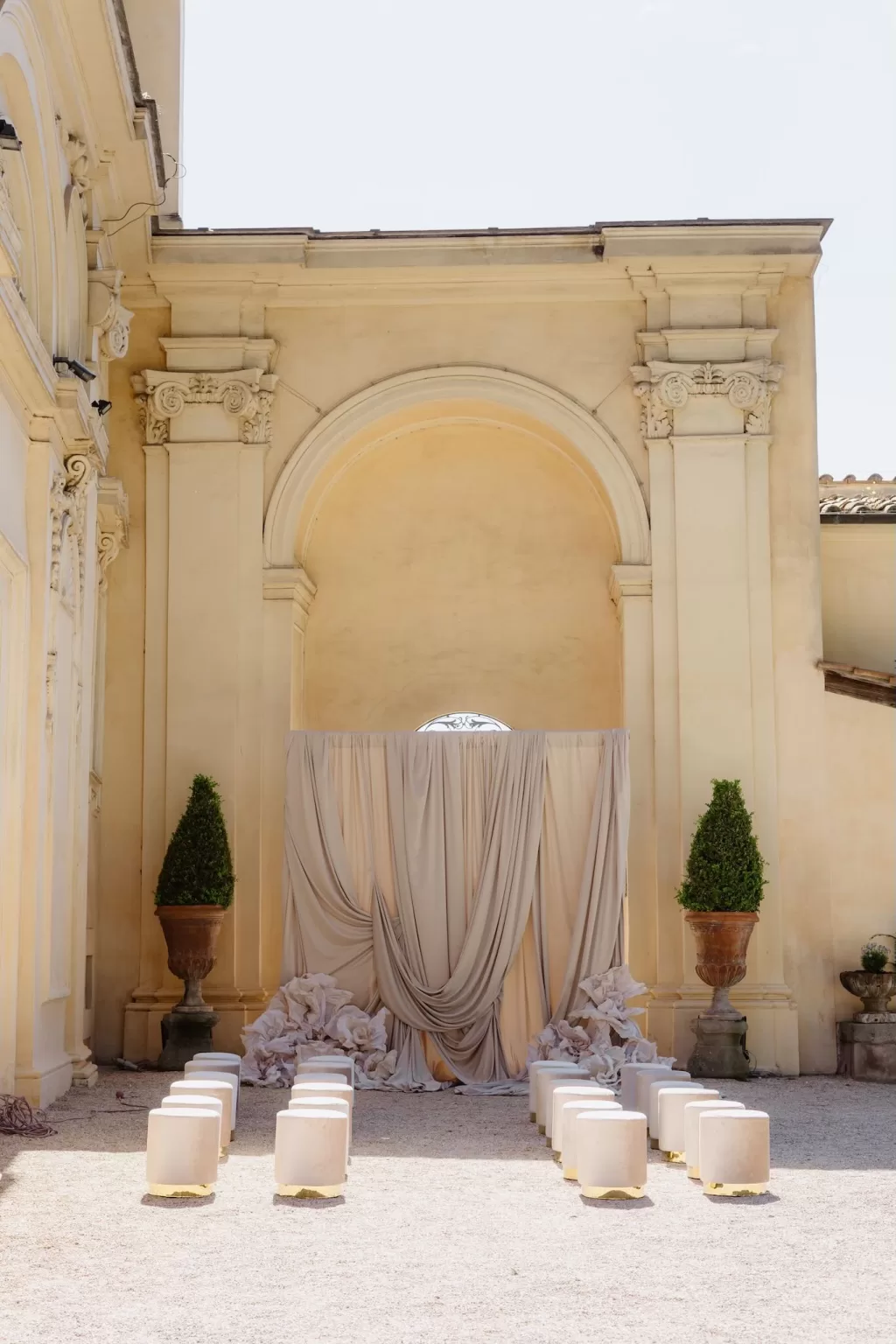 Ceremony space at Villa Aurelia with draped backdrop and stone aisle seating