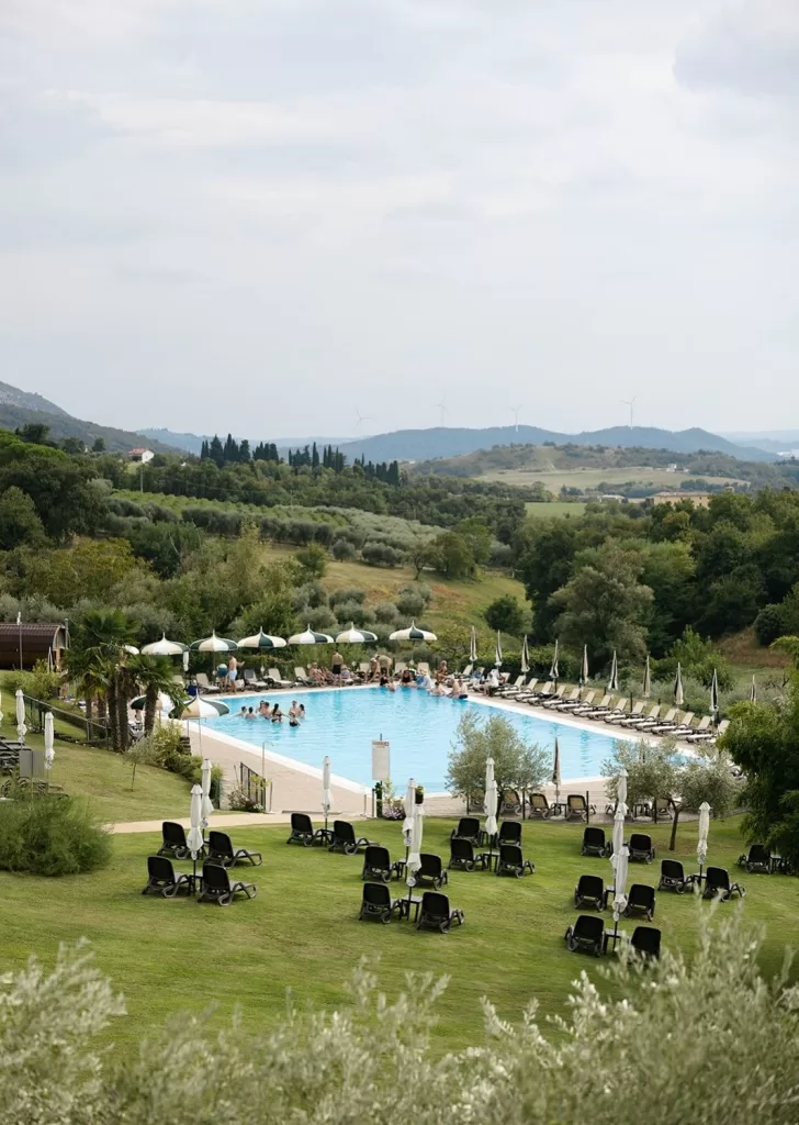Villa Cariola’s pool nestled among rolling green hills and olive trees in the Italian countryside.