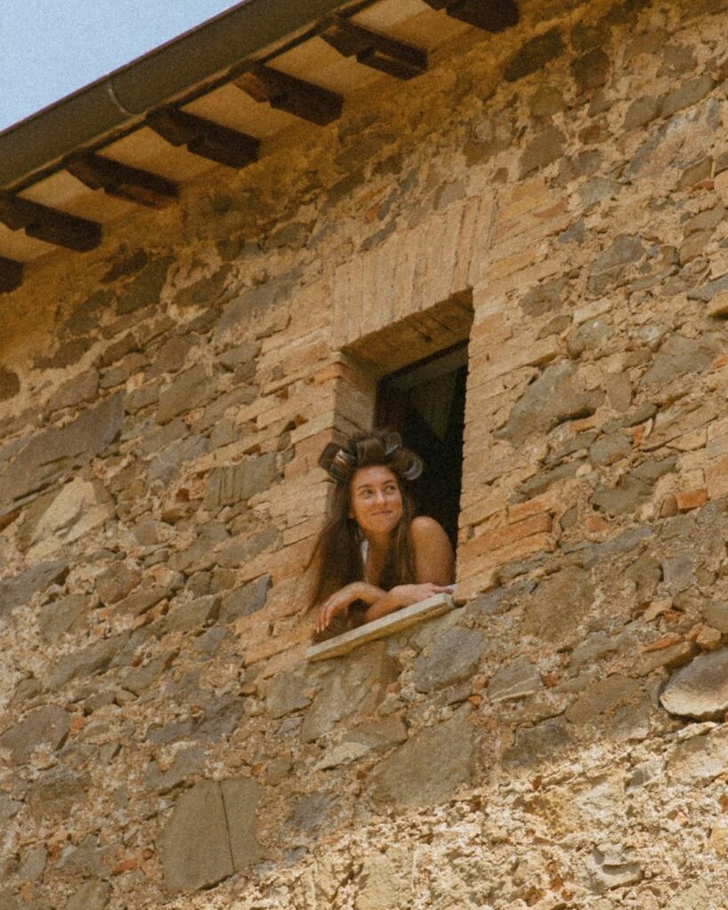 Bride gazing out the window in anticipation on her wedding day at Antico Convento.