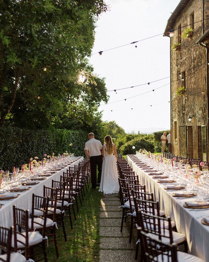 Newlyweds walking hand in hand at sunset in the gardens of Antico Convento.