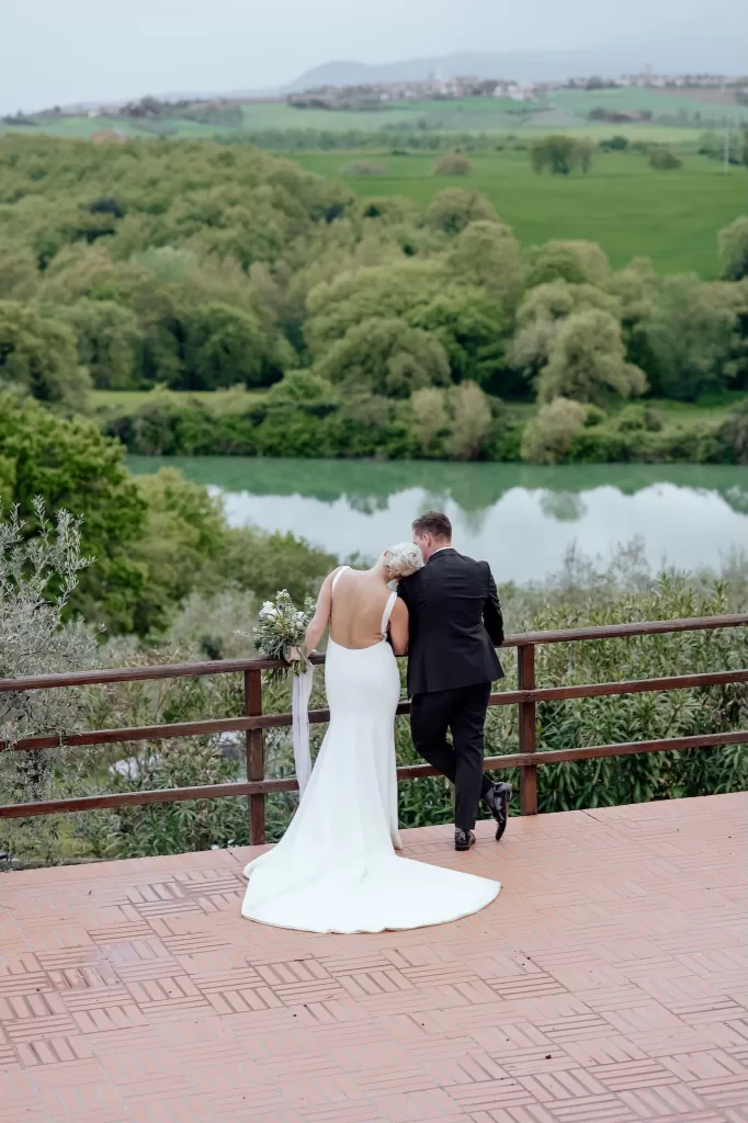 Bride and groom share a quiet moment overlooking the lake and green hills at Borgo Sant'Ambrogio.