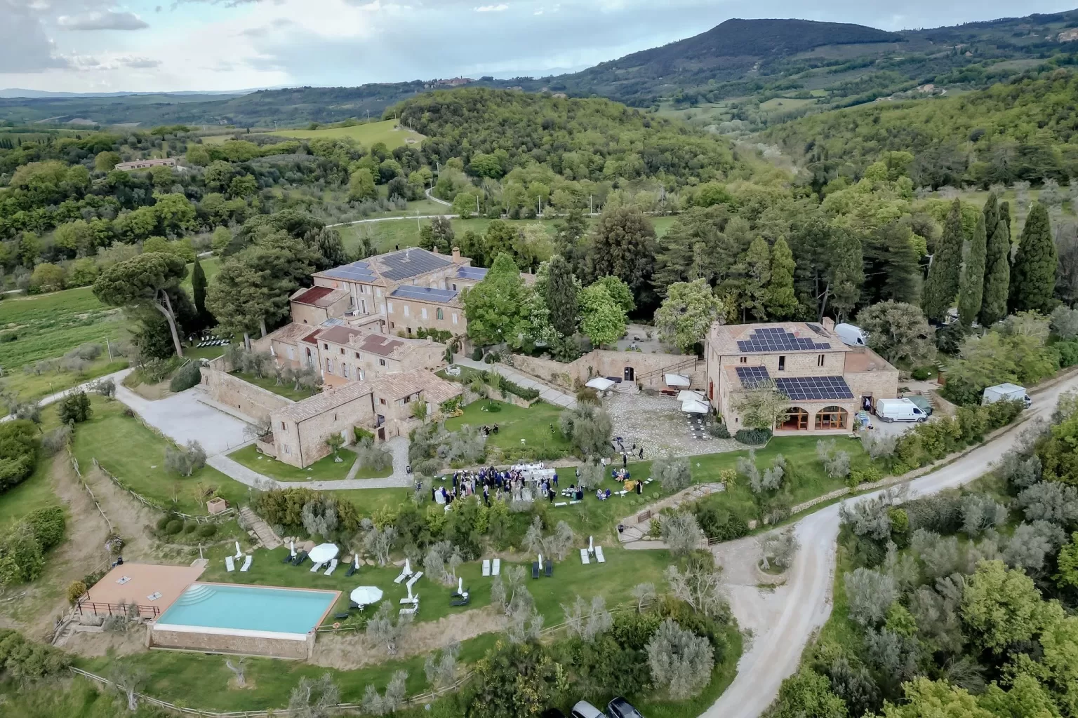 Aerial view of Borgo Sant'Ambrogio wedding venue surrounded by Tuscan hills and olive groves.