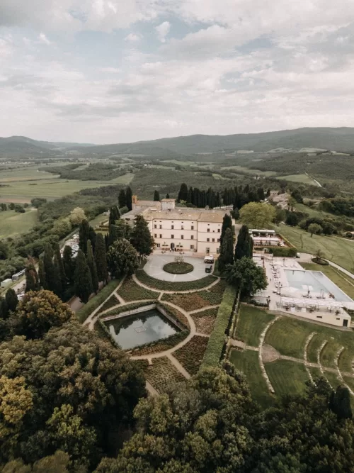 Hilltop view of Castello di Casole estate with sweeping landscape and Tuscan architecture.