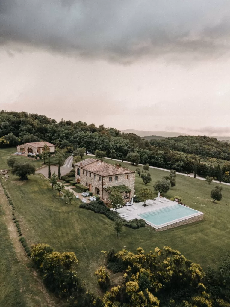 Stone villa with infinity pool and manicured gardens at Castello di Casole, Tuscany.