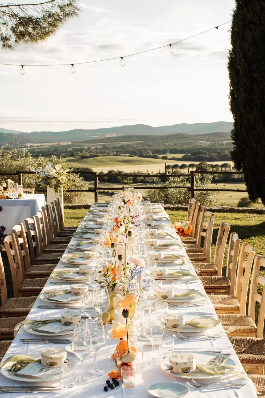 Reception table set with fruit and wildflowers under golden light at Conti di San Bonifacio.
