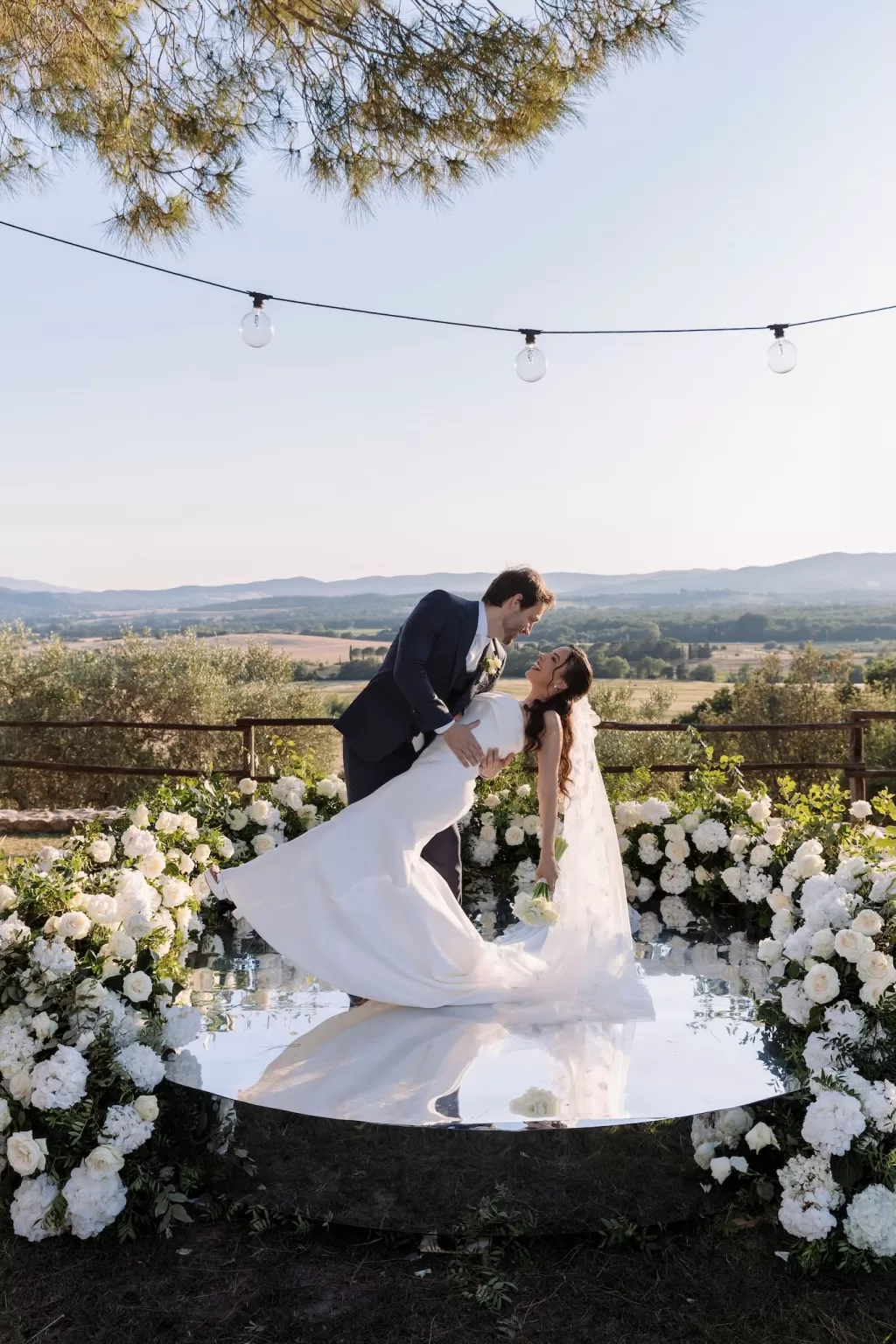 Groom dipping the bride for a kiss on the floral ceremony platform at Conti di San Bonifacio.