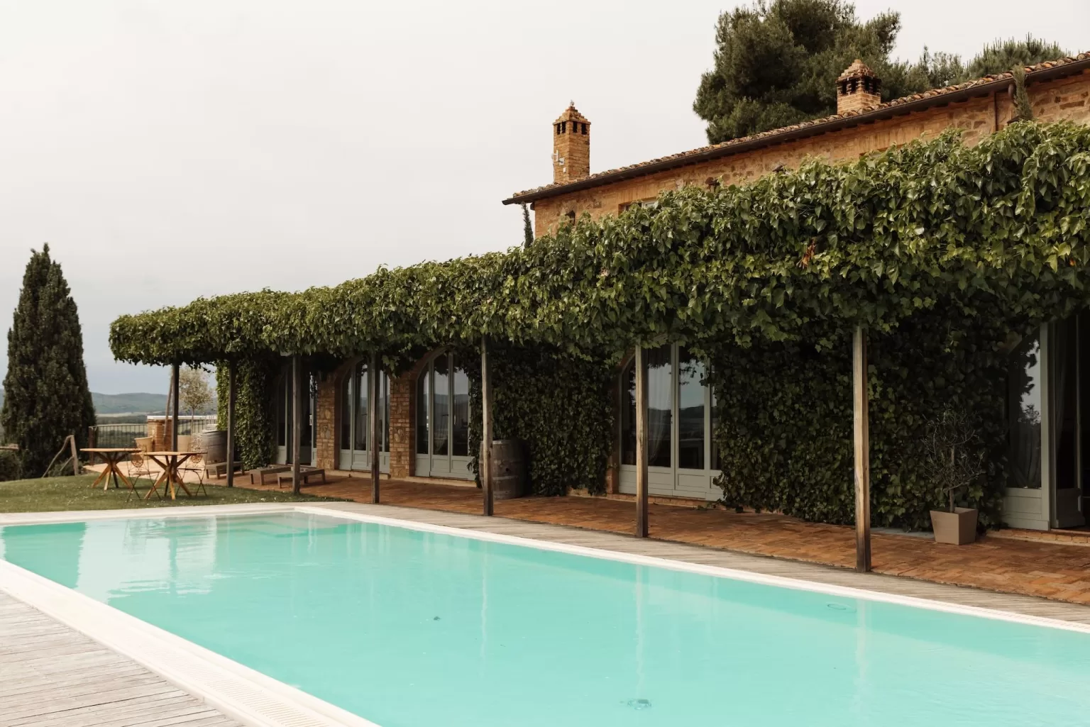 Serene pool terrace with ivy-covered walls and countryside views at Conti di San Bonifacio.