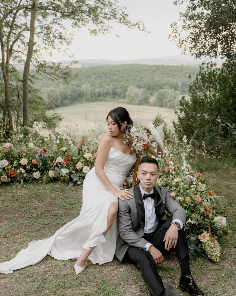 A romantic couple's portrait framed by lush floral decor at Borgo Sant'Ambrogio, blending nature and love in a stunning setting.