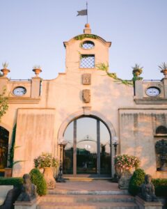 Grand facade of Tenuta Corbinaia, a luxurious Tuscan wedding venue surrounded by rolling vineyards and cypress trees.