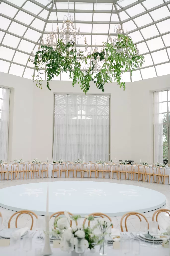 Elegant wedding reception under glass dome at Luna Escondida, with natural light and hanging greenery.